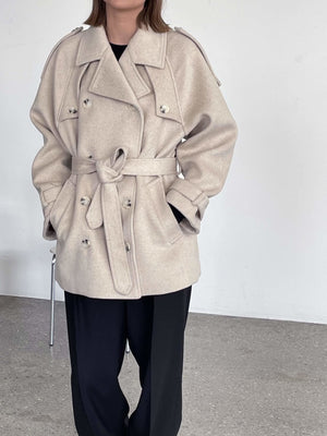 A stylish beige trench coat with a belted waist, featuring large buttons and a relaxed fit, perfect for a chic look by MEOTINE.