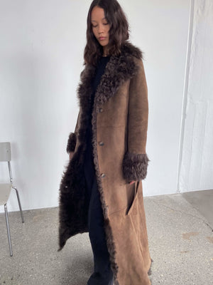 A model showcases a stylish brown coat with a fur collar and cuffs, embodying elegance and warmth, perfect for winter by MEOTINE.
