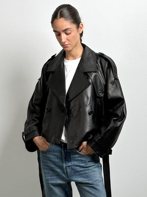 A model wears a stylish black cropped leather jacket with a relaxed fit, paired with light blue jeans, showcasing MEOTINE's chic design.
