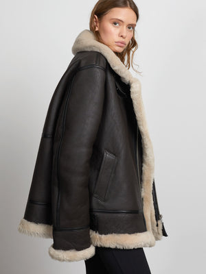 Stylish black shearling jacket with a cozy fur collar, perfect for a chic winter look. MEOTINE offers warmth and elegance.