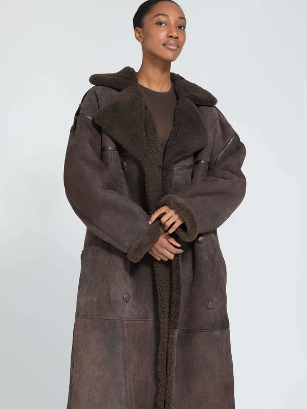 A model showcases a stylish brown oversized coat with a plush collar, embodying the cozy elegance of MEOTINE.