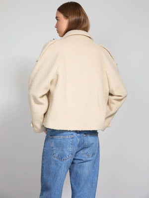 Cozy cream-colored jacket with a textured finish, featuring a relaxed fit and stylish shoulder details, by MEOTINE.