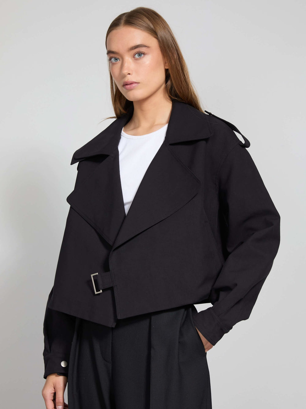 Stylish black cropped jacket with a belted waist and wide lapels, paired with a simple white top, showcasing MEOTINE's modern design.