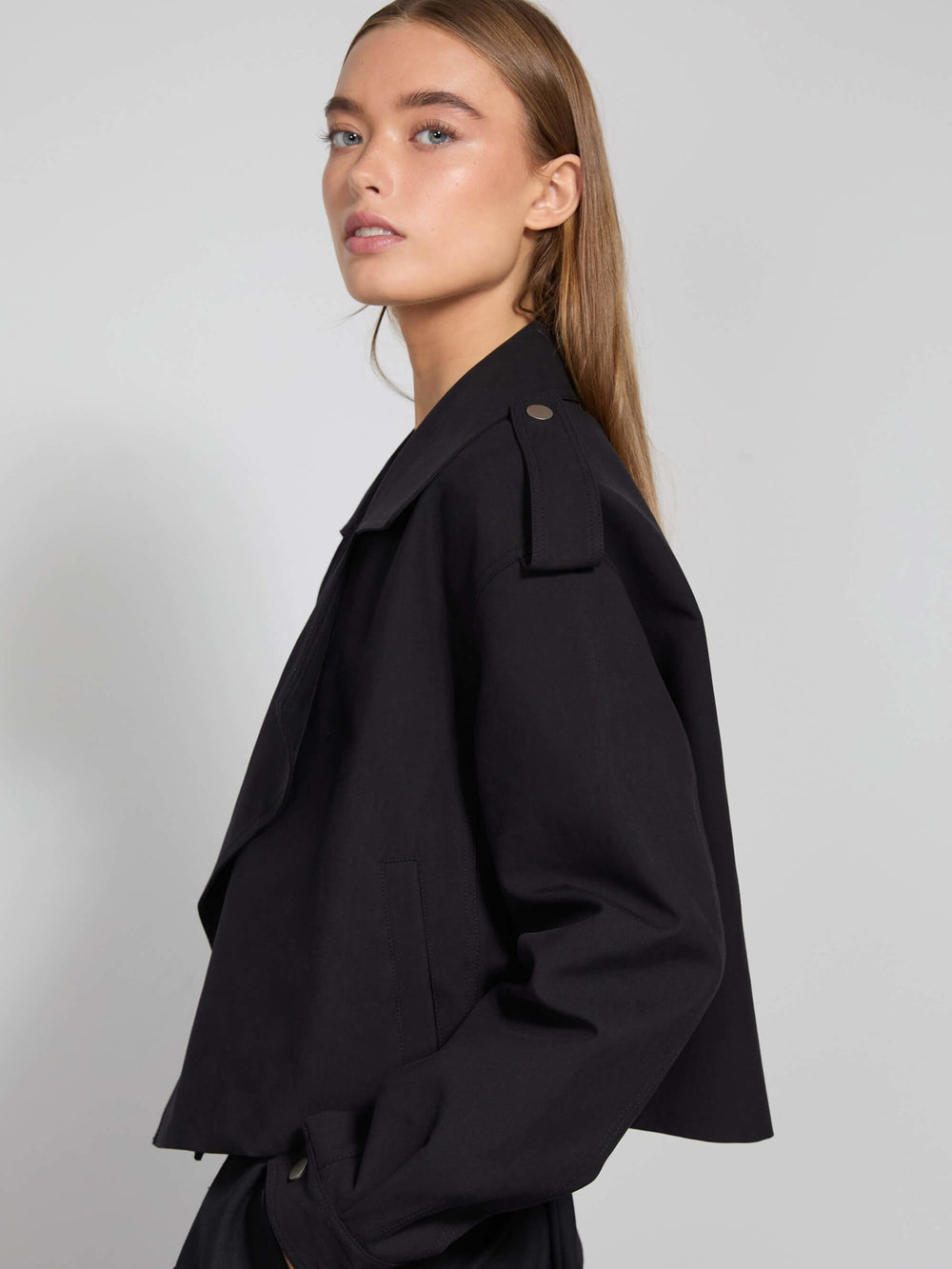 Stylish black cropped jacket with a belted waist and wide lapels, paired with a simple white top, showcasing MEOTINE's modern design.