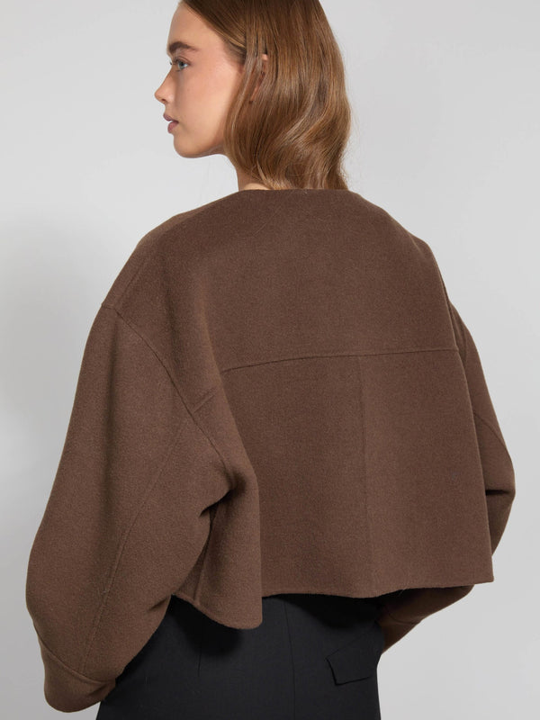 A model showcases a stylish brown cropped jacket with a relaxed fit, perfect for layering in cooler weather. MEOTINE.