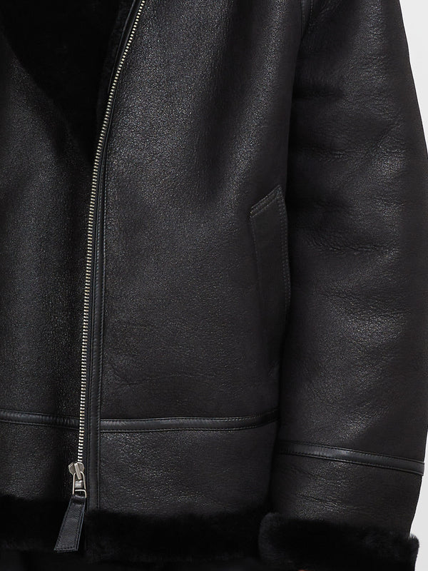 Black leather jacket with a soft shearling lining, featuring a zip closure and side pockets, by MEOTINE.