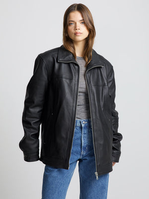 Stylish black leather jacket from MEOTINE, featuring a relaxed fit and zip closure, paired with a casual gray top and blue jeans.