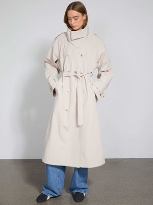 A stylish beige trench coat with a high collar and belt, paired with wide-leg jeans, showcasing MEOTINE's modern design.