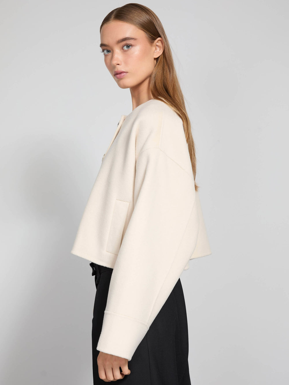 A model wears a cream-colored cropped jacket with large buttons and side pockets, showcasing MEOTINE's stylish design.