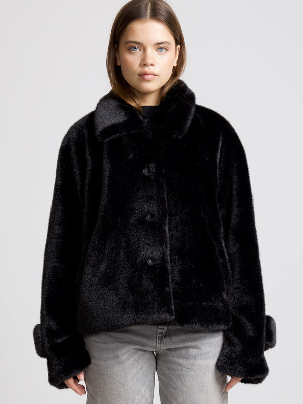 Cozy black faux fur jacket with a button-up front and wide collar, perfect for stylish warmth by MEOTINE.