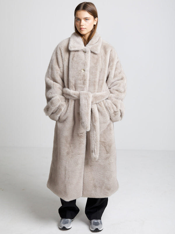 Cozy beige faux fur coat with a belted waist and oversized fit, perfect for stylish warmth this season. MEOTINE brand.