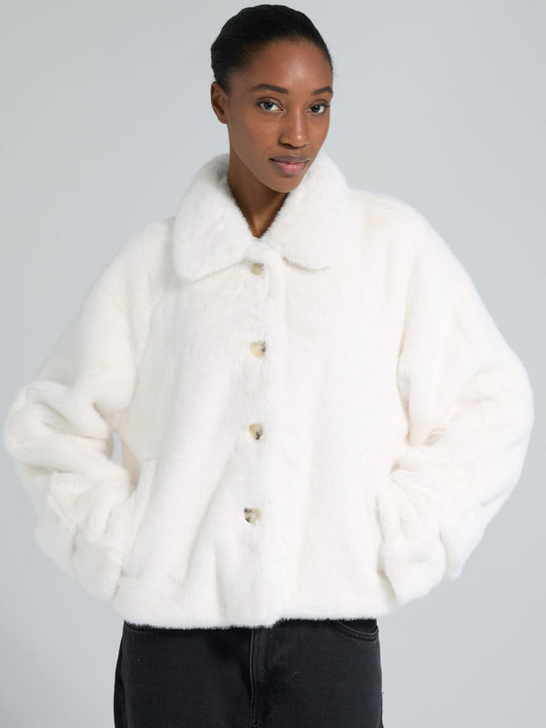 Cozy white faux fur jacket with a collar and button closure, perfect for stylish warmth. From MEOTINE's latest collection.