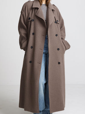 A stylish long brown coat with a relaxed fit, featuring a double-breasted design and large buttons, perfect for layering by MEOTINE.