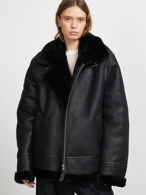 A model wears a stylish black shearling jacket with a plush collar, showcasing MEOTINE's modern and cozy design.