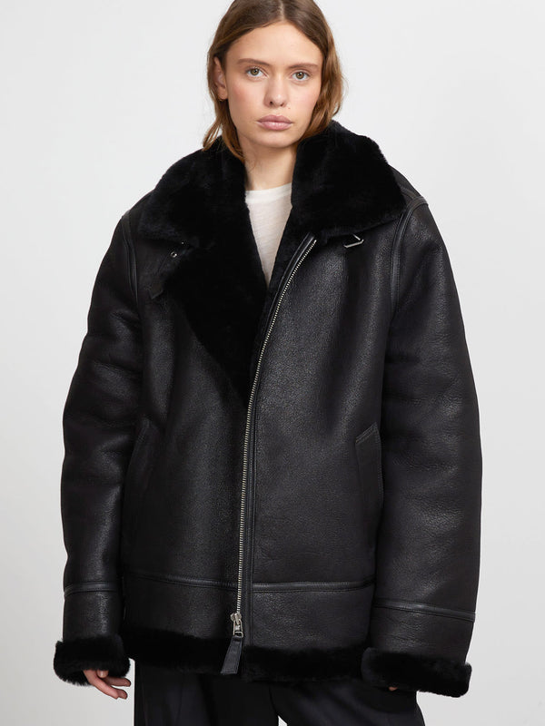 A model wears a stylish black shearling jacket with a plush collar, showcasing MEOTINE's modern and cozy design.
