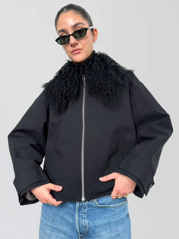 A model wearing a black jacket with a faux fur collar, styled with sunglasses, showcasing MEOTINE's trendy outerwear.
