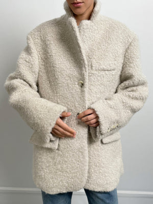 Cozy beige MEOTINE oversized coat with a textured finish, featuring a high collar and front pockets, styled with denim.