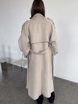 A stylish beige coat with a belted waist, featuring a relaxed fit and elegant design, perfect for a chic look by MEOTINE.