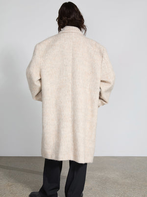A person wearing a soft, beige MEOTINE coat, viewed from the back, showcasing its oversized fit and cozy texture.