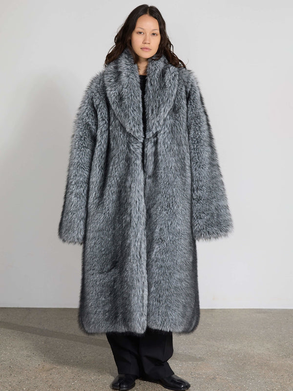 A model showcases a luxurious gray faux fur coat by MEOTINE, featuring a wide collar and oversized silhouette, perfect for winter.