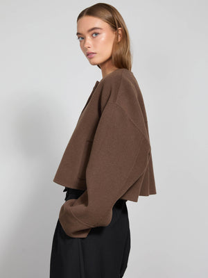 A model showcases a brown cropped sweater with a relaxed fit, paired with black trousers, embodying MEOTINE's chic style.