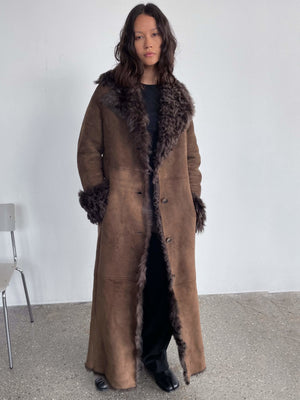 A model showcases a stylish brown coat with a fur collar and cuffs, embodying MEOTINE's chic and cozy aesthetic.