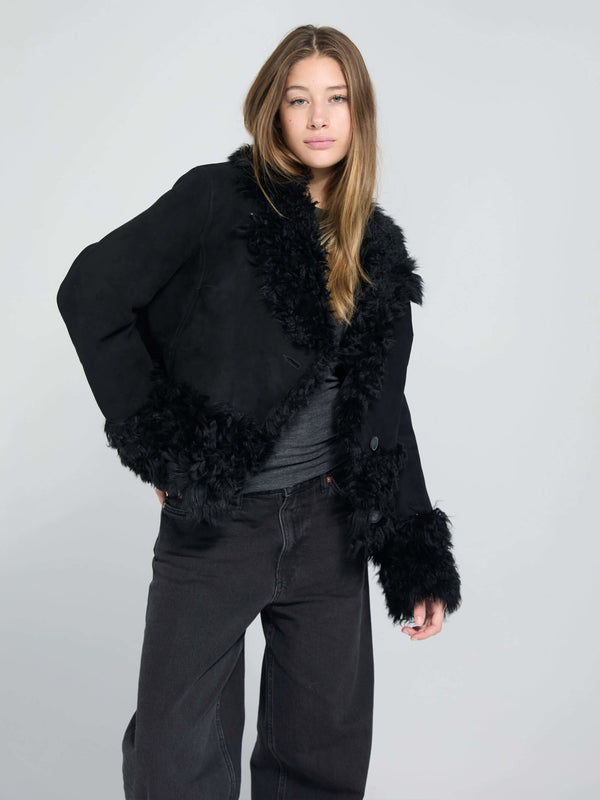 Stylish black jacket with fluffy trim, featuring a chic design perfect for a trendy look. By MEOTINE.