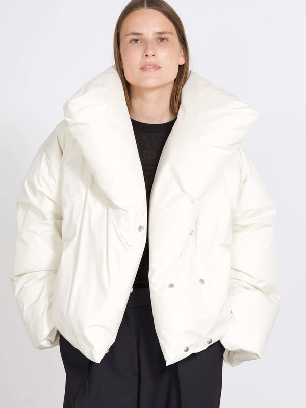 A model wears a stylish oversized white puffer jacket with a dramatic collar, showcasing MEOTINE's modern design.