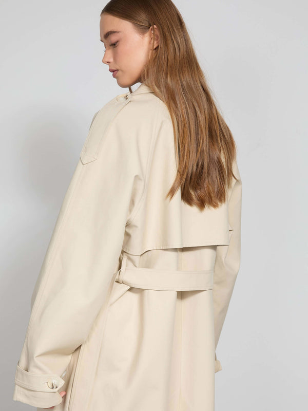 A model showcases a stylish beige trench coat with a belted waist and a relaxed fit, embodying MEOTINE's chic aesthetic.