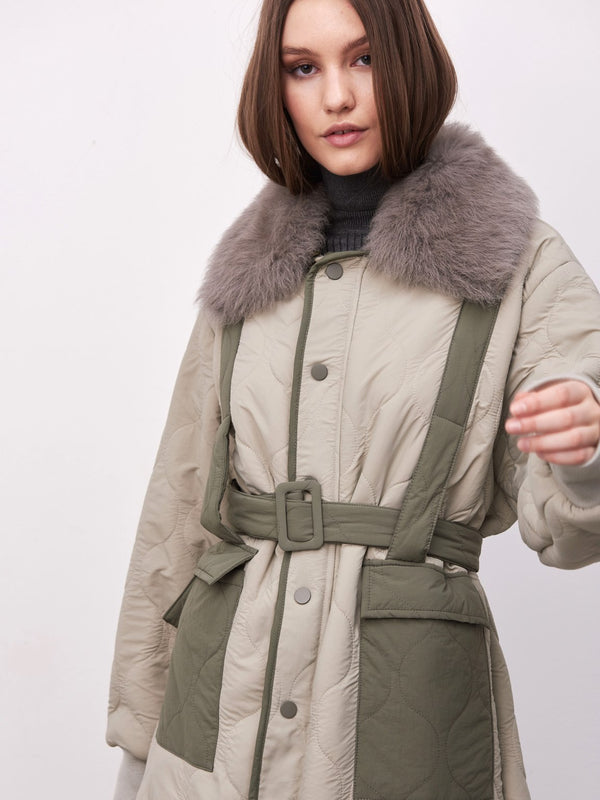 A stylish quilted coat featuring a faux fur collar and a belted waist, perfect for a chic winter look by MEOTINE.