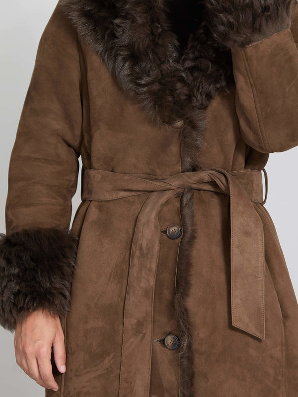 Brown suede coat with a fur collar and cuffs, featuring a belted waist and button closure. Perfect for stylish warmth by MEOTINE.