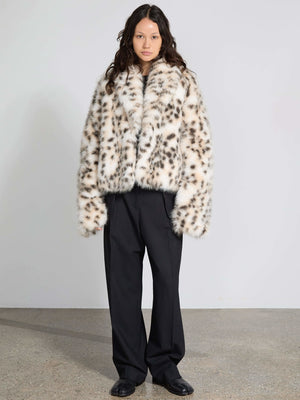 Stylish model wearing a MEOTINE leopard print faux fur coat paired with loose black trousers, set against a minimalist backdrop.