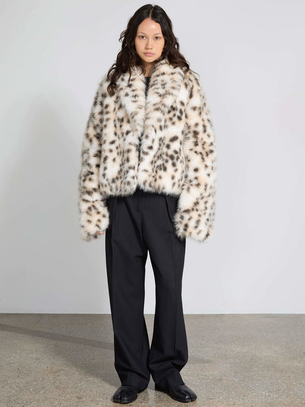Stylish model wearing a MEOTINE leopard print faux fur coat paired with loose black trousers, set against a minimalist backdrop.