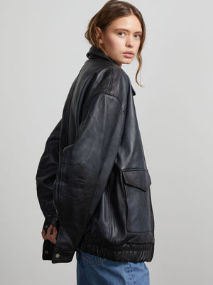 A model showcases a stylish black leather jacket with a relaxed fit and elastic hem, embodying MEOTINE's modern aesthetic.
