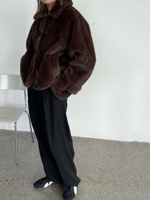 A model showcases a cozy brown faux fur jacket paired with loose black pants, exuding a chic, casual vibe by MEOTINE.