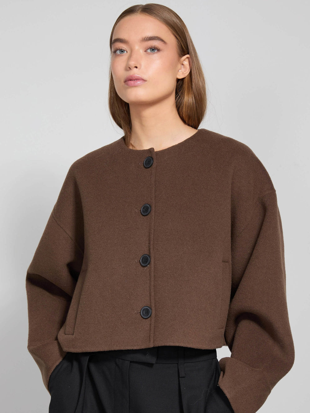 Brown cropped jacket with a round neckline and large buttons, styled with relaxed sleeves, perfect for a chic look by MEOTINE.