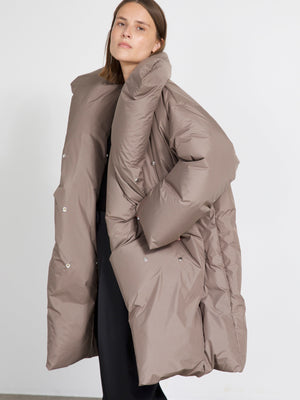 A model wearing a stylish oversized brown puffer coat by MEOTINE, showcasing a modern and cozy winter look.