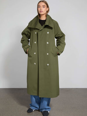 A model showcases a stylish olive green trench coat with a double-breasted design, featuring large buttons and side pockets by MEOTINE.