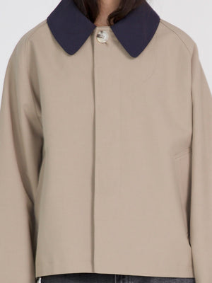 A stylish beige jacket with a navy collar, featuring a button closure and a relaxed fit, perfect for casual wear by MEOTINE.