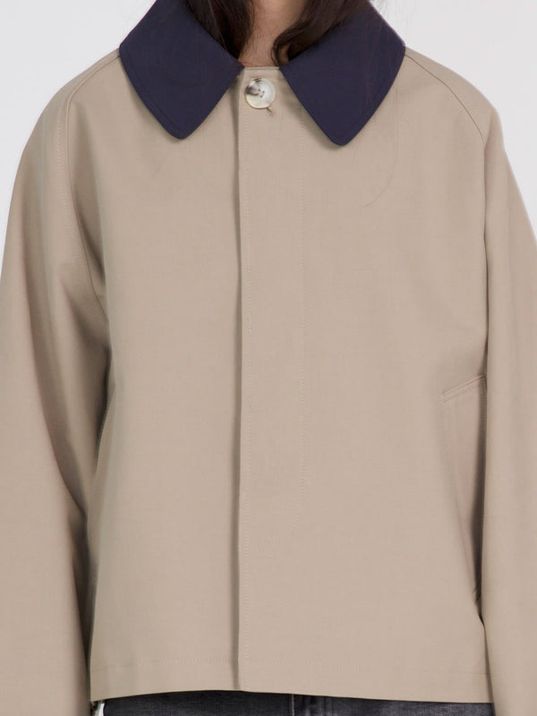 A stylish beige jacket with a navy collar, featuring a button closure and a relaxed fit, perfect for casual wear by MEOTINE.