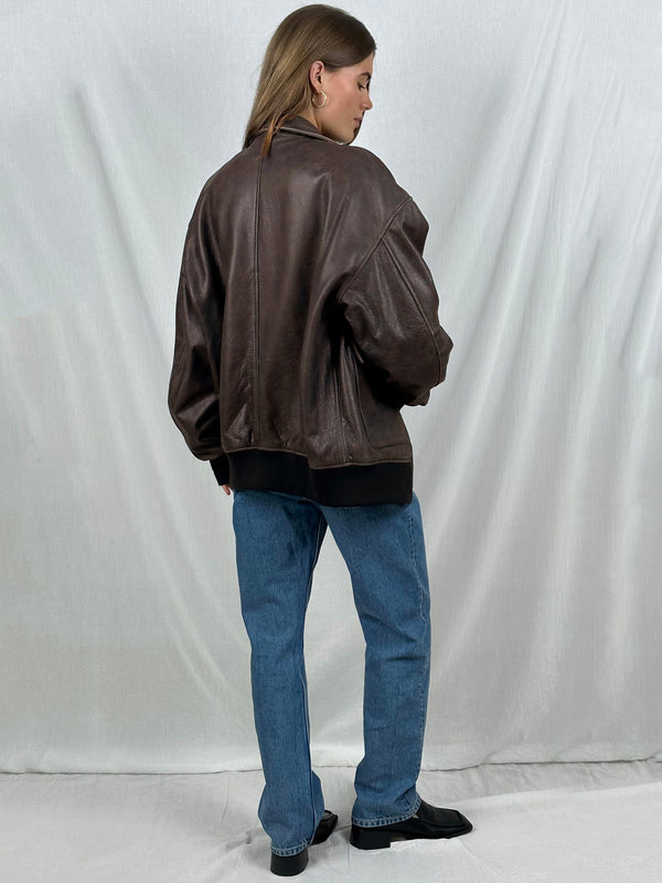 A model showcases a stylish brown leather jacket from MEOTINE, paired with blue jeans, exuding a chic and modern vibe.