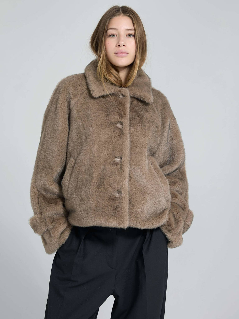 A model wears a cozy, oversized brown faux fur jacket with a collar and button closure, showcasing MEOTINE's stylish design.