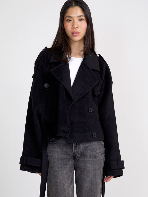 A model wears a stylish black cropped coat with a double-breasted design, paired with gray jeans, showcasing MEOTINE's chic aesthetic.