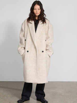 A model wears a cozy, oversized cream coat with a double-breasted design, showcasing MEOTINE's stylish winter collection.