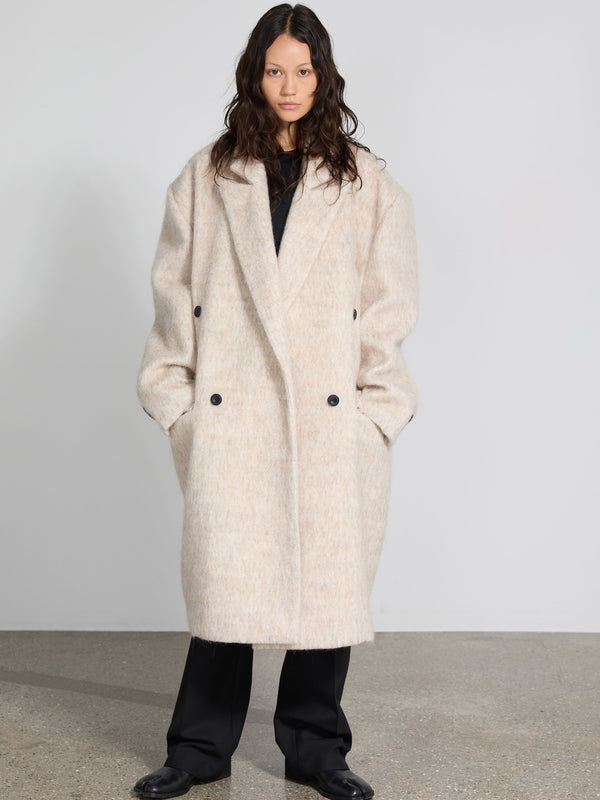 A model wears a cozy, oversized cream coat with a double-breasted design, showcasing MEOTINE's stylish winter collection.