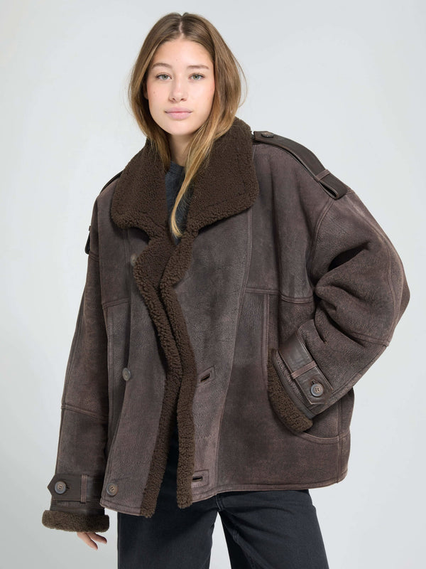 A model wears a cozy, oversized brown shearling jacket with a plush collar, showcasing MEOTINE's stylish winter outerwear.