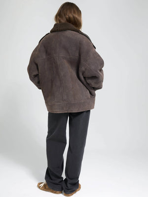Oversized brown jacket with a cozy collar, paired with black pants, showcasing a relaxed, stylish look by MEOTINE.