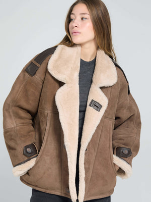 Cozy brown shearling jacket with a plush collar and leather accents, perfect for stylish warmth this season by MEOTINE.