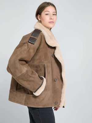 Brown shearling jacket with a cozy collar and leather accents, worn by a model, showcasing MEOTINE's stylish design.