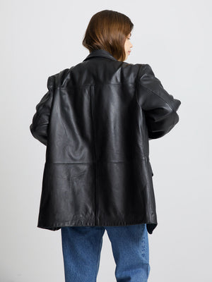 A woman wearing a stylish black leather blazer from MEOTINE, showcasing a relaxed fit and elegant design from the back.